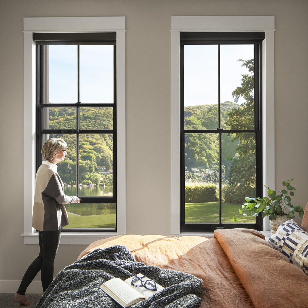 Woman standing in front of Pella Reserve Double Hung Windows